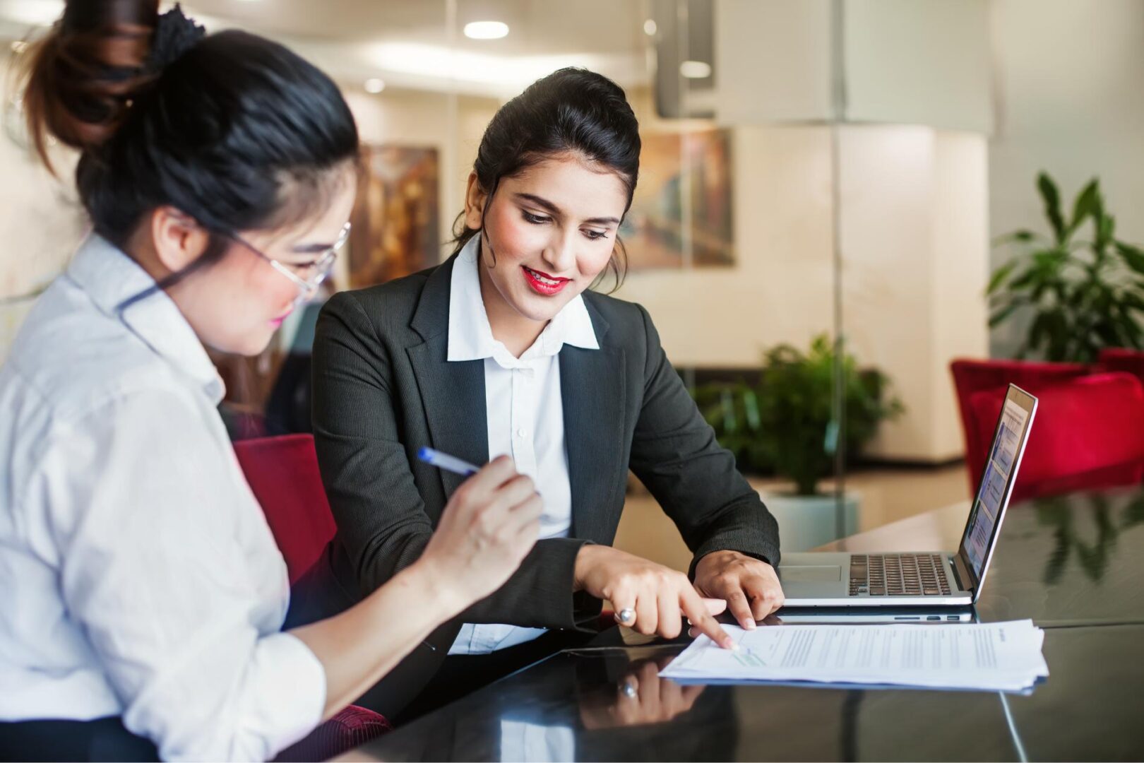 Two businesswomen reviewing documents together.